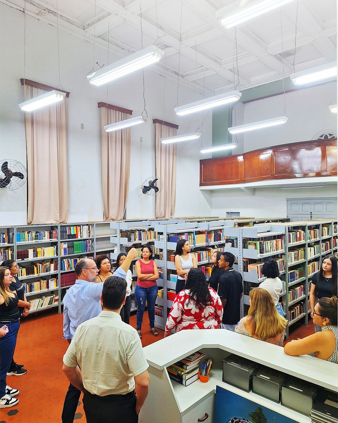 Alunos entre as estantes da biblioteca do IMES São Manuel